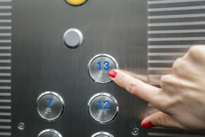 Vrouw klikt op knop 13 in lift