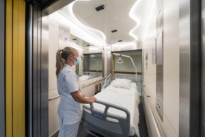 Verpleegster met ziekenhuisbed in lift